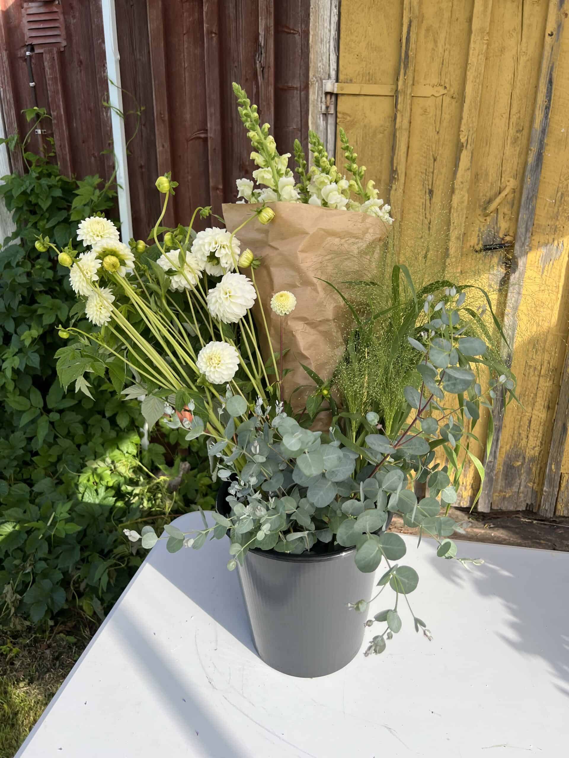 a bucket of mixed flowers & greenery