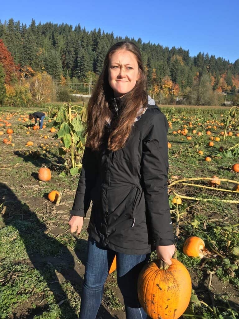 Woman holding a pumpkin in a pumpkin patch