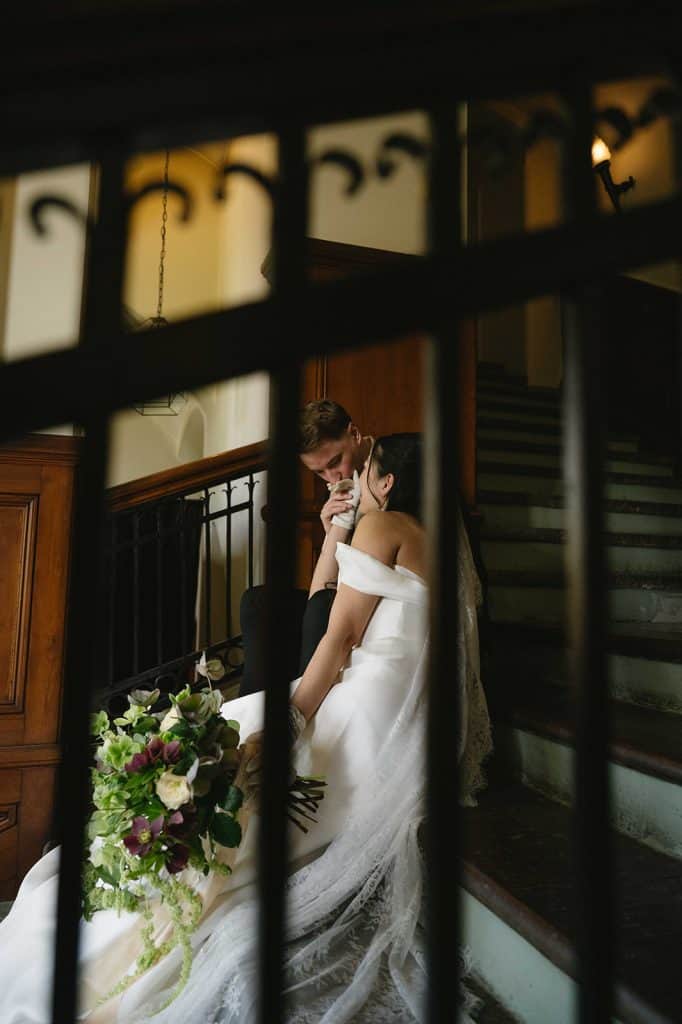 secret shot of bride and groom sitting on a staircase