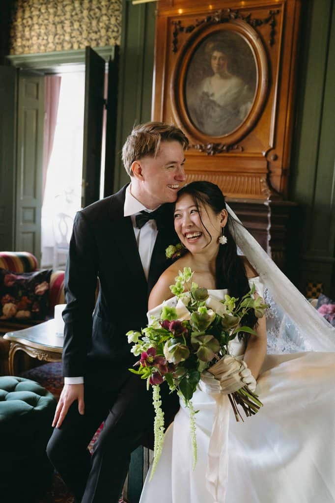 bride and groom sitting in a dark green room